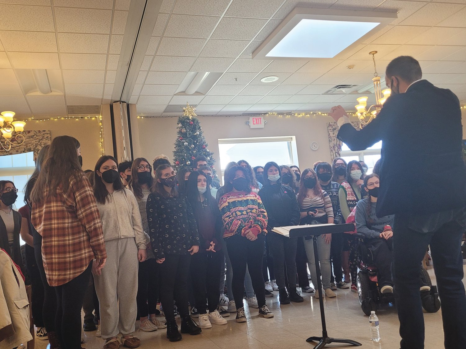 SINGING STUDENTS: Johnston High School Chorus Director Matt Gingras conducts his group of singing students at a recent Johnston Senior Center performance.